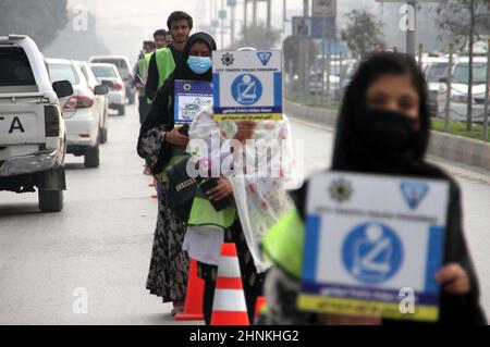 Die Teilnehmer der Freiwilligen-Organisation für den Straßenverkehr halten am Donnerstag, dem 17. Februar 2022, in Peshawar Informationsbroschüre und Horten über die Verkehrssicherheit während der Kampagne für Verkehrsgesetze und Straßenverkehrssicherheit ab. Stockfoto