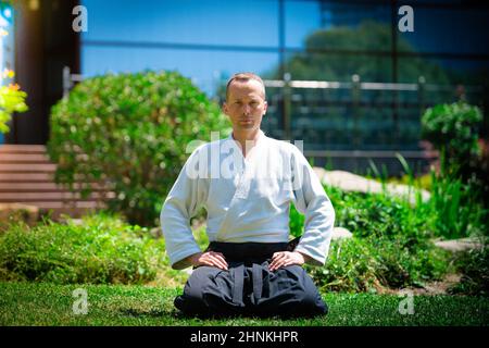 Junge ernster Mann aikido Master in traditioneller Tracht Stockfoto