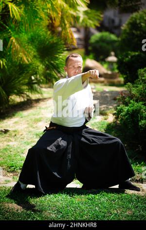 Junge ernster Mann aikido Master in traditioneller Tracht Stockfoto