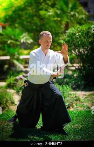 Junge ernster Mann aikido Master in traditioneller Tracht Stockfoto