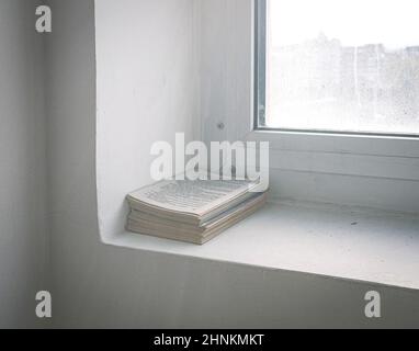 Ein Abfallpapier aus unordentlichen Papieren auf der Fensterbank Stockfoto