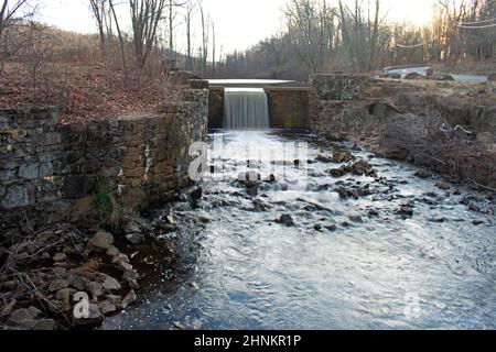 Langzeitbelichtung eines kleinen Wasserfalls im Davidson's Mill Pond Park, South Brunswick, New Jersey, USA, im Winter -02 Stockfoto