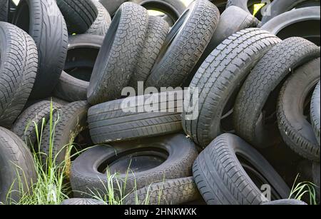 Beschädigte und abgenutzte alte schwarze Reifen auf einem Stapel. Beschädigte und abgenutzte alte schwarze Reifen auf einem Stapel. Probleme mit der Reifenlauffläche. Lösungskonzept. Probleme mit der Reifenlauffläche. Stockfoto