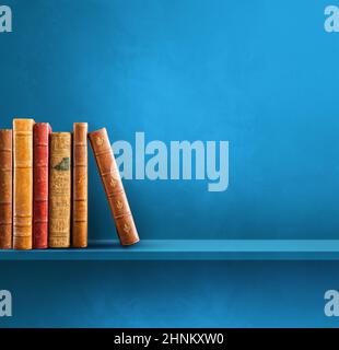 Reihe alter Bücher auf blauem Regal. Quadratischer Hintergrund Stockfoto