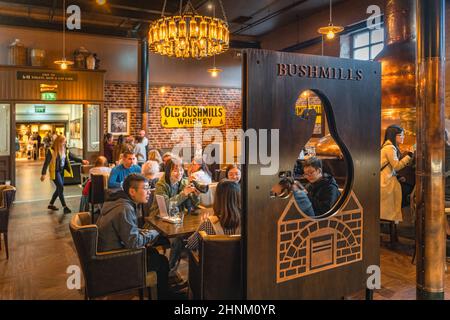 Touristen besuchen die Old Bushmills Distillery und probieren irischen Whiskey in einer Bar Stockfoto