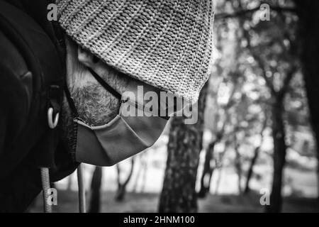 Junger Mann mit Maske und Mütze Stockfoto