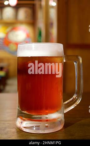 Nahaufnahme ein Becher gekühltes Bier, das auf einem Holztisch serviert wird Stockfoto
