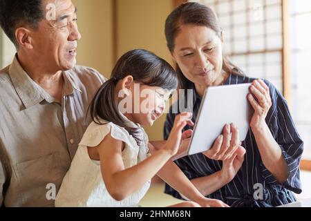 Japanische Großeltern Und Enkelkinder Mit Tablet-Geräten Stockfoto