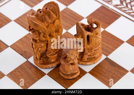 Indische Sandelholz-Schachfiguren auf einem Brett Stockfoto