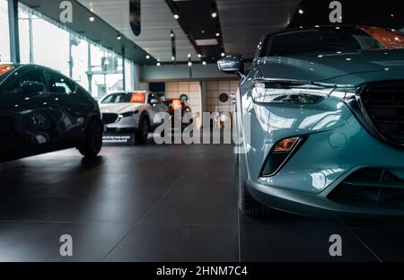 Selektiver Fokus graues Auto in Luxus-Showroom geparkt. Autohaus. Neues Auto in modernem Showroom geparkt. Auto zu verkaufen und mieten Business-Konzept. Kfz-Leasing und Versicherungshintergrund. Stockfoto