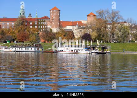 Wawel Königsschloss, Blick von der Seite des Flusses Wisla an einem Herbsttag, Lastkähne und Restaurants, Krakau, Polen Stockfoto