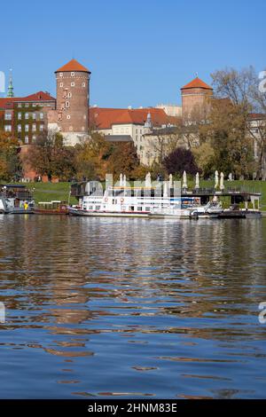 Wawel Königsschloss, Blick von der Seite des Flusses Wisla an einem Herbsttag, Lastkähne und Restaurants, Krakau, Polen Stockfoto