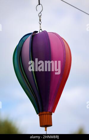 Ein Windspiel in Form eines Ballons hängt an einer Linie und dreht sich im Wind. Stockfoto