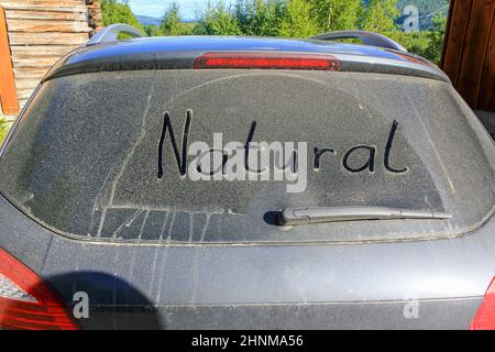 Worte NATUR auf der staubigen, schmutzigen Windschutzscheibe eines Autos Stockfoto