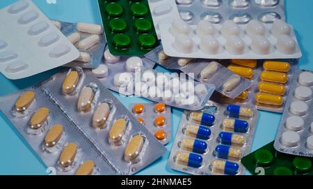 Stapel von Pillen in Blisterpackungen auf blauem Hintergrund. Stockfoto