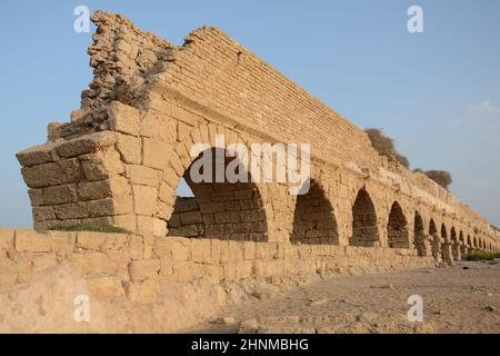 Ein altes Aquädukt auf hohem Niveau. Die Überreste des Herodianischen Aquädukts in der Nähe der antiken Stadt Caesarea, Israel. Stockfoto