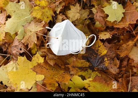 FFP2-Maske im Laub, vierte Corona-Welle im Herbst, Österreich, Europa - FFP2 Maske im Laub, vierte Koronawelle im Herbst, Österreich, Europa Stockfoto