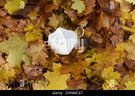 FFP2-Maske im Laub, vierte Corona-Welle im Herbst, Österreich, Europa - FFP2 Maske im Laub, vierte Koronawelle im Herbst, Österreich, Europa Stockfoto