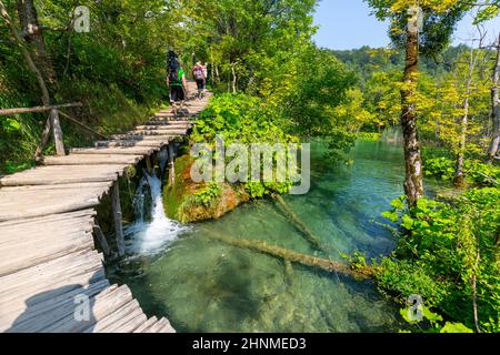 Nationalpark Plitvicer Seen, ein Wunder der Natur, Touristen zu Fuß auf der Holzbrücke, Plitvicer Seen, Kroatien Stockfoto