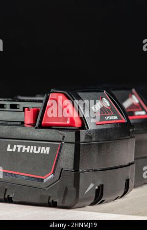 Akku für Akku-Bohrmaschine. Schrauberbatterie. Vier Akkus mit Ladeanzeige auf schwarzem Hintergrund Stockfoto