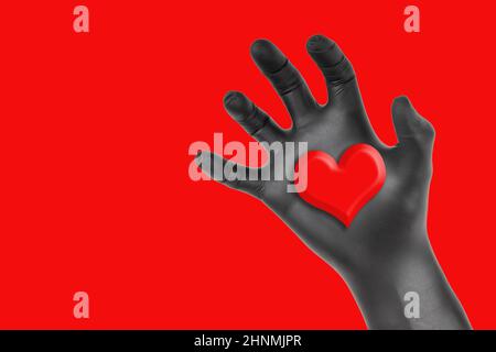 Schwarze Handschuhen, die ein auf rotem Hintergrund isoliertes Herz ergreifend. Konzept des romantischen Herzklau. Stockfoto
