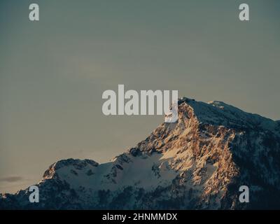 Snowy Mountain bei Sonnenaufgang mit blauem Himmel // schneebedckter Berg im Sonnenaufgang mit blauem Himmel Stockfoto