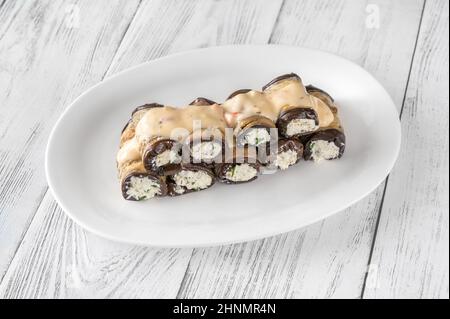 Gefüllte Auberginen-Brötchen mit Feta unter Senfsauce Stockfoto