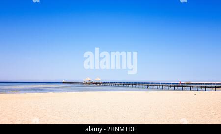 Ein schöner Strand ohne Menschen und ein tropisch blaues Meer mit blauem Himmel. Stockfoto