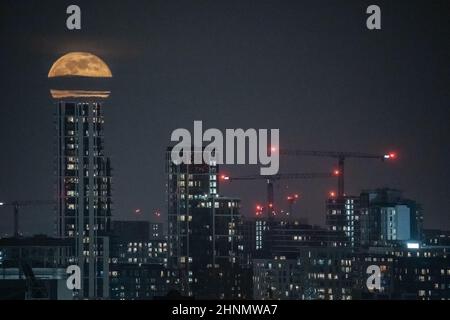 London, Großbritannien. 17th. Februar 2022. UK Wetter: Mondaufgang 98,8% Wachsen der Gibbos steigt um 18:17 Uhr über der Stadt. Kredit: Guy Corbishley/Alamy Live Nachrichten Stockfoto