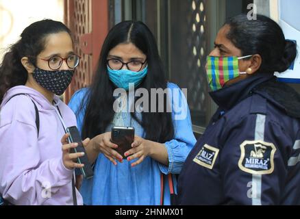 Neu-Delhi, Indien. 17th. Februar 2022. Studenten, die Gesichtsmask tragen, folgen der Covid-19-Richtlinie, die am ersten Tag der Wiederaufnahme des Studiums mit ihren Telefonen beobachtet wurde. Miranda House College for Women, North Campus University of Delhi, wird nach zwei Jahren Schließung aufgrund der Covid-19-Pandemie wieder eröffnet. Kredit: SOPA Images Limited/Alamy Live Nachrichten Stockfoto