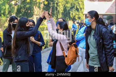 Neu-Delhi, Indien. 17th. Februar 2022. Studenten, die Gesichtsmasken trugen, die der covid-19-Richtlinie folgten, sahen am ersten Tag der Wiederaufnahme des Studiums hohe fünf Gesten. Miranda House College for Women, North Campus University of Delhi, wird nach zwei Jahren Schließung aufgrund der Covid-19-Pandemie wieder eröffnet. Kredit: SOPA Images Limited/Alamy Live Nachrichten Stockfoto