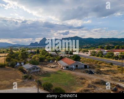Entferntes Drohnenantenpanorama des UNESCO-Denkmals Meteora mit einem Bauernhaus im Vordergrund Stockfoto