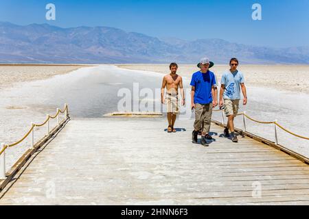 Touristen besuchen das trockene Salzmeer von badwater im Death Valley, dem tiefsten Landpunkt der USA. Stockfoto