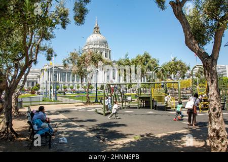 Die Menschen besuchen den Kinderspielplatz vor dem Rathaus in San Francisco. Erwachsene ohne Kinder dürfen den Bereich nicht betreten Stockfoto