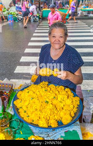 Unbekannte Frau verkauft am frühen Morgen Blumen auf dem Blumenmarkt Pak Klong Thalat Stockfoto