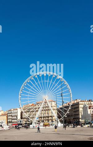 Die Menschen genießen in Marseille ein großes Riesenrad gegen den blauen Himmel Stockfoto