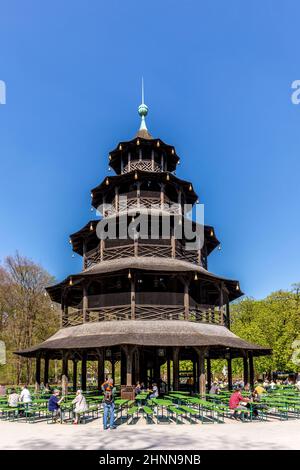 Die Menschen genießen den Biergarten in der Nähe des chinesischen Turms im englischen Garten in München, Bayern, Deutschland. Stockfoto