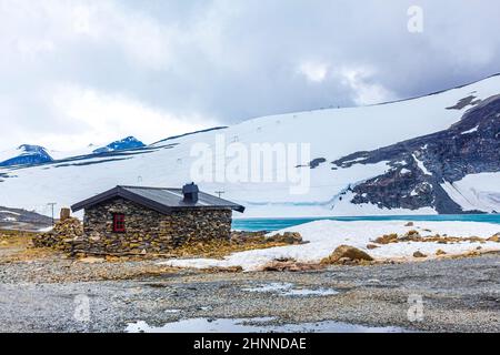 Steinhütte in Galdhøpiggen im Sommer schneebedeckt in Jotunheimen Lom in Norwegen ist der größte und höchste Berg in Norwegen und Skandinavien wi Stockfoto