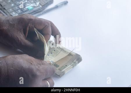 Ältere Mann Hand Zählen indische Rupie Notiz auf dem Tisch. High-Angle-Ansicht. Nahaufnahme. Stockfoto