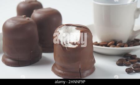 Weiße Schokolade Krembo auf dem Tisch. Ein schokoladenbeschichtetes Marschmallchen, das in Israel beliebt ist. Stockfoto