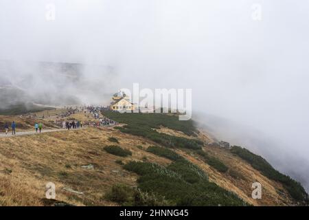 KARPACZ, POLEN - 16. OKTOBER 2021: Touristen besteigen den beliebten polnischen Berggipfel Sniezka im Riesengebirge bei bewölktem Wetter. Stockfoto