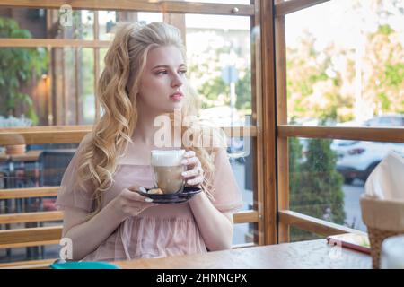 Perfekte Frau genießt ihren morgendlichen Cappuccino im Café Stockfoto