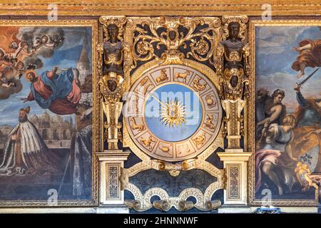 Innenraum des Dogenpalastes (Palazzo Ducale) - Wand mit Uhr. Der Dogenpalast wurde im venezianischen gotischen Stil erbaut und ist eines der wichtigsten Wahrzeichen der Stadt Venedig. Stockfoto