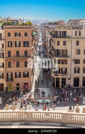 Die Menschen genießen die spanische Treppe auf der Piazza di Spagna in Rom. Spanische Treppe mit dem Brunnen Barcaccia in Rom ist ein berühmtes Touristenziel Stockfoto