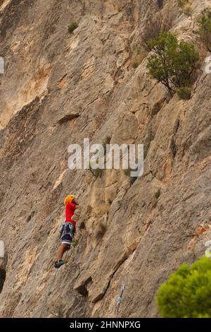 BUSOT, ALICANTE, SPANIEN - 3. SEPTEMBER 2018: Mann übt Klettern in der Umgebung der canelobre Höhlen in der Stadt busot in der Provinz Stockfoto