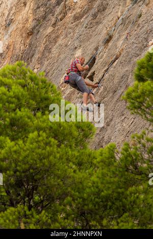 BUSOT, ALICANTE, SPANIEN - 3. SEPTEMBER 2018: Mann übt Klettern in der Umgebung der canelobre Höhlen in der Stadt busot in der Provinz Stockfoto