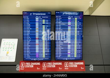 Ankunfts- und Abfahrtszeiten an einer Schildertafel am römischen Flughafen Fiumicino, teilweise in russischer Sprache Stockfoto