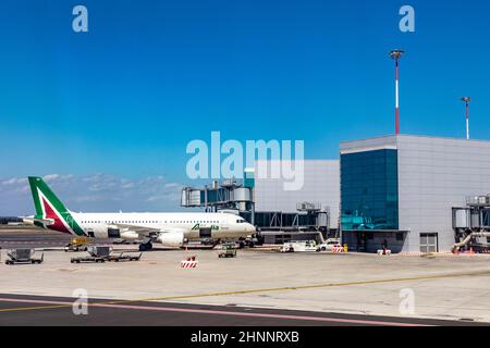 Blick auf den römischen Flughafen Fiumicino in Rom mit Flugzeug am Gate. Es ist der größte Flughafen in Italien. Stockfoto