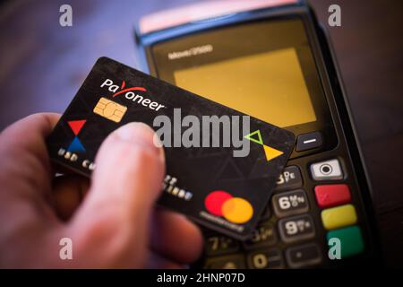 Payoneer-Karte in der Nähe eines POS-Terminals Stockfoto