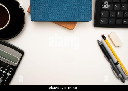 Bürobedarf Über Dem Schreibtisch Mit Tastatur Und Brille Und Kaffeetasse Für Die Fernarbeit, Verschiedene Schuleinrichtungen Für Das Studium Mit Heißgetränk Und Brille. Stockfoto